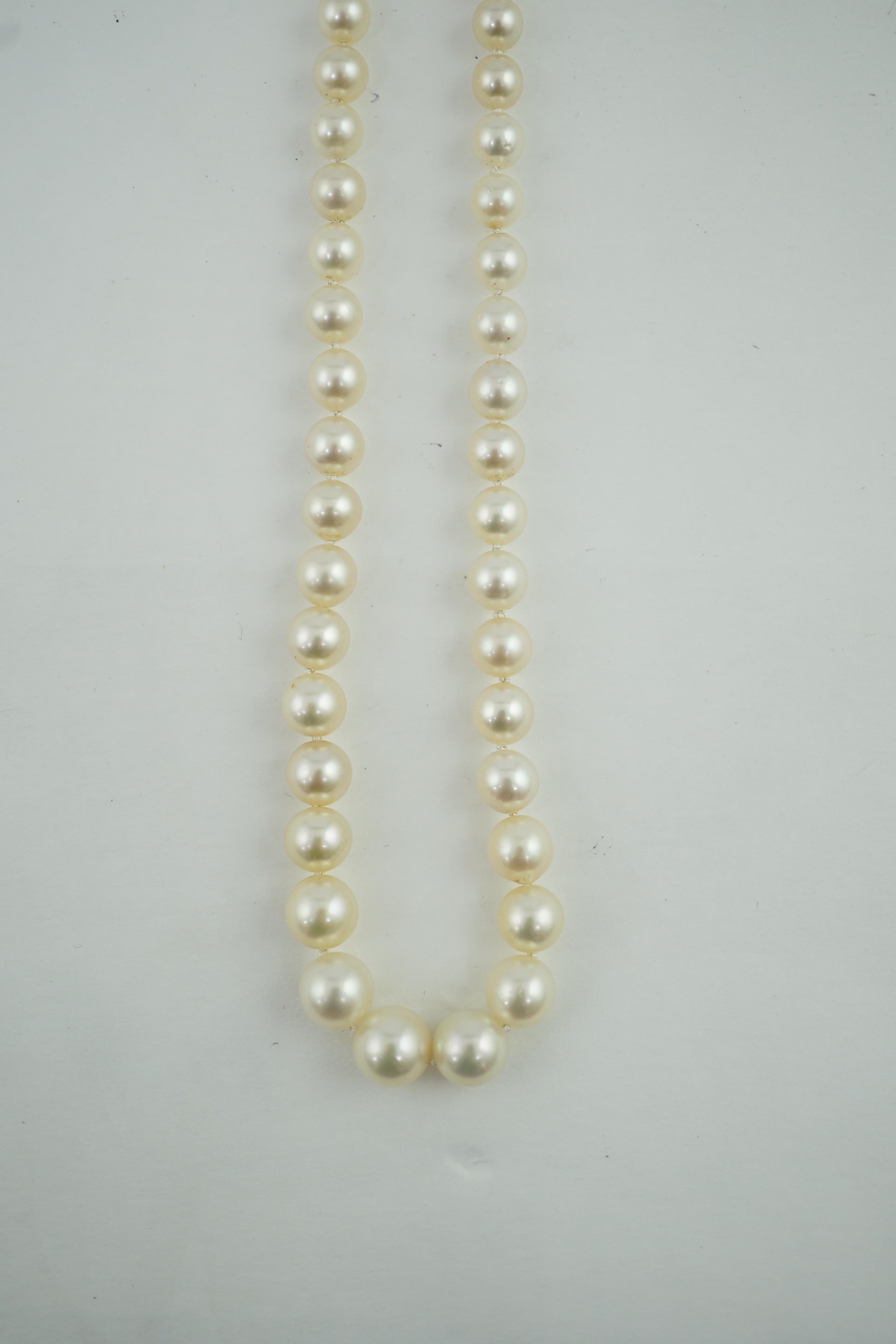 A single strand graduated cultured pearl necklace, with a gold, garnet and rose cut diamond cluster set clasp